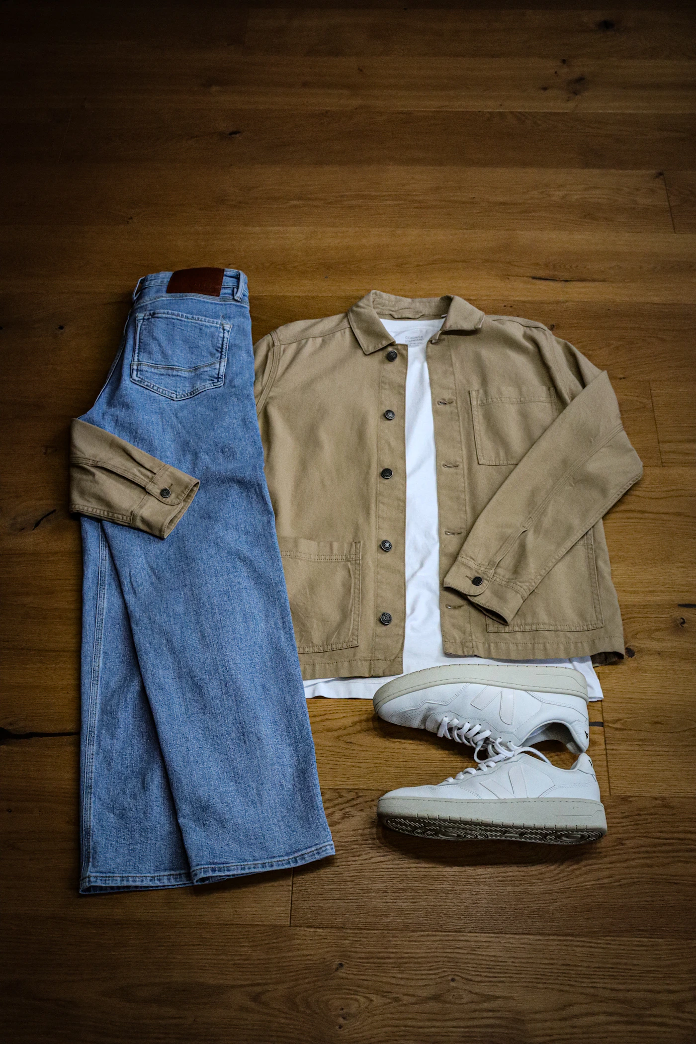 Casual outfit with jeans, jacket and sneakers laid out