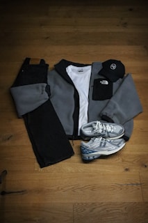 A pair of sneakers and a jacket on a wooden floor