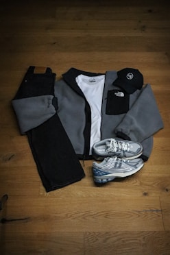 A pair of sneakers and a jacket on a wooden floor