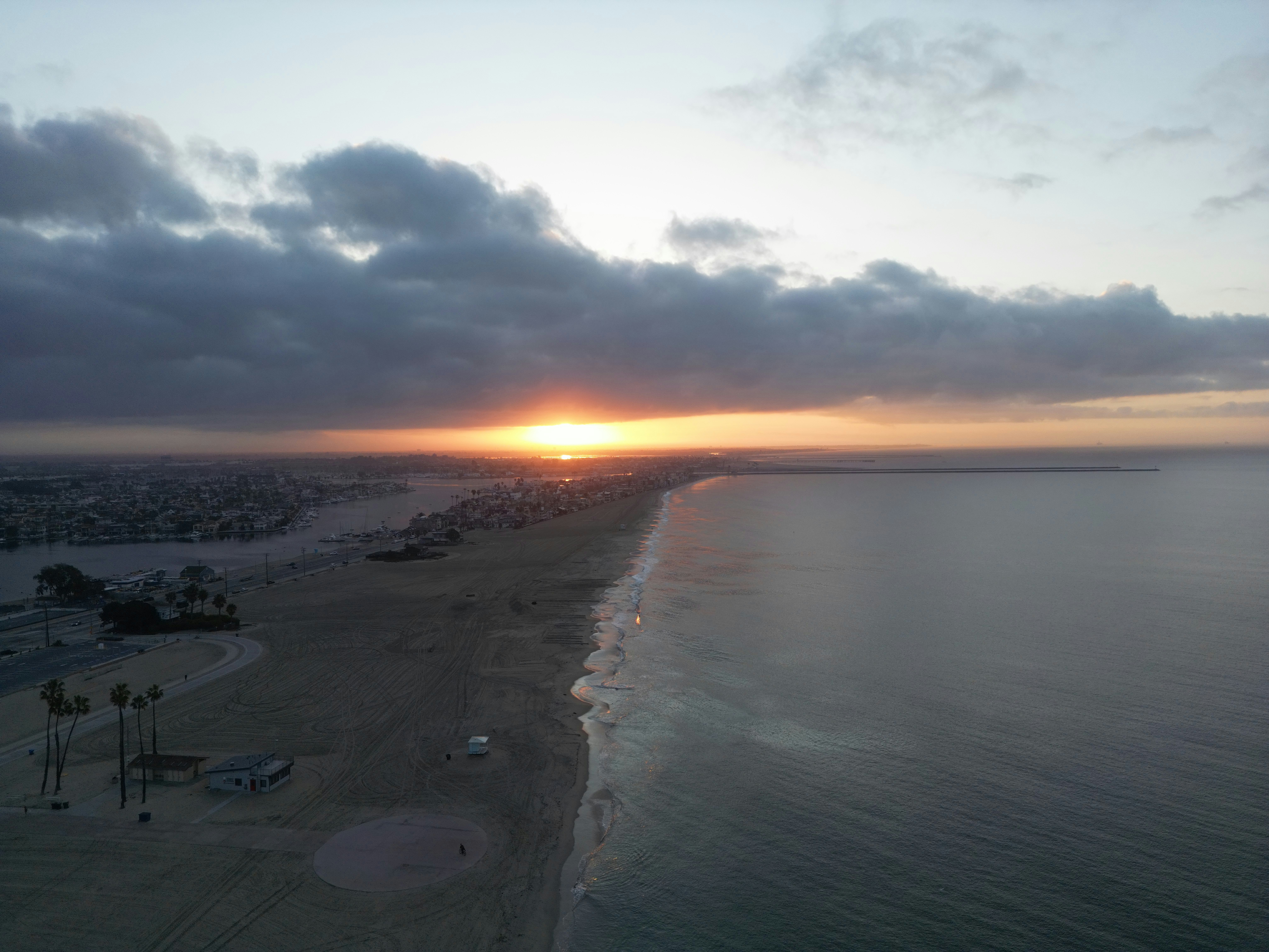 The sun is setting over the beach and the ocean