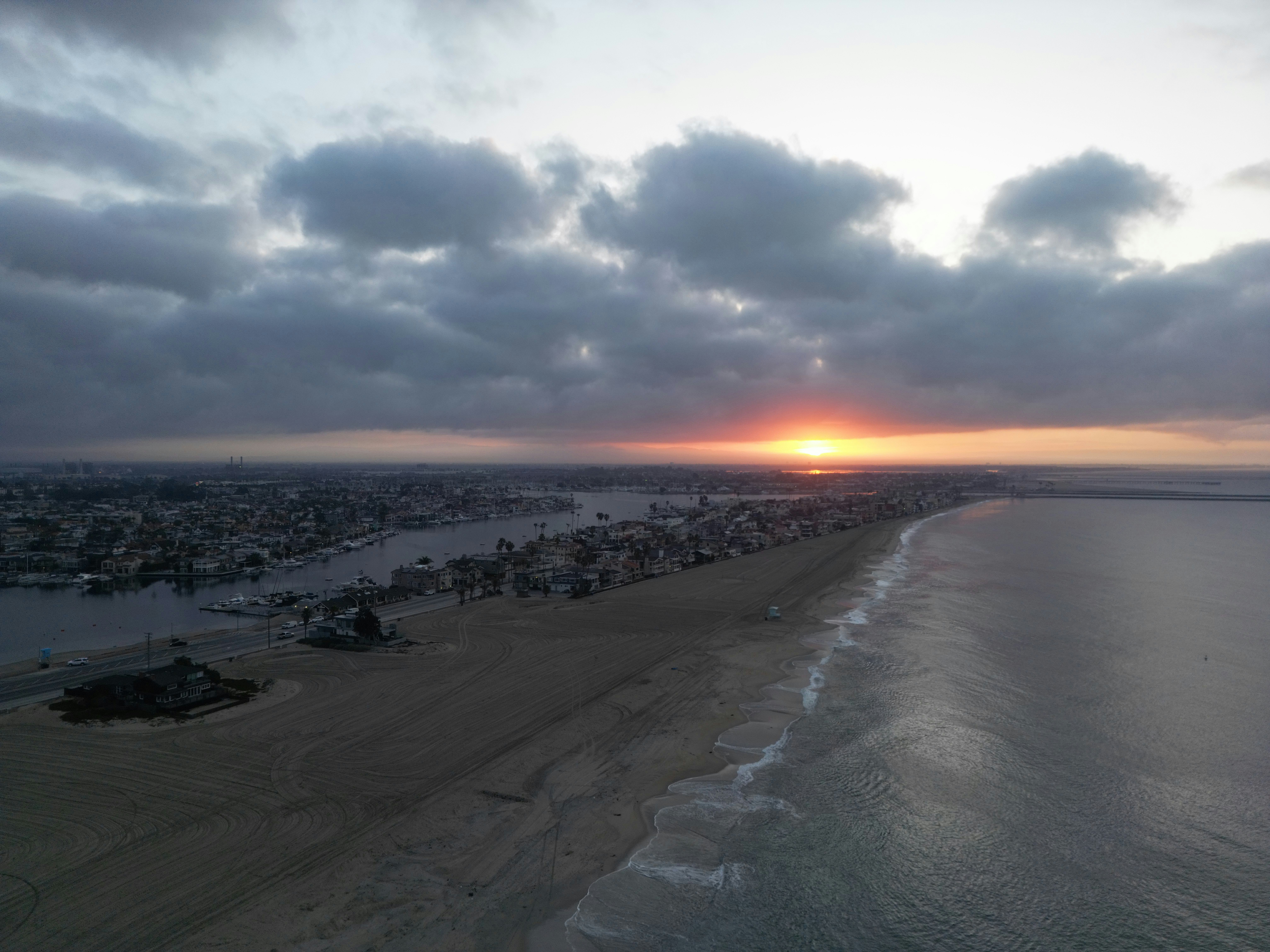 The sun is setting over the beach and the ocean