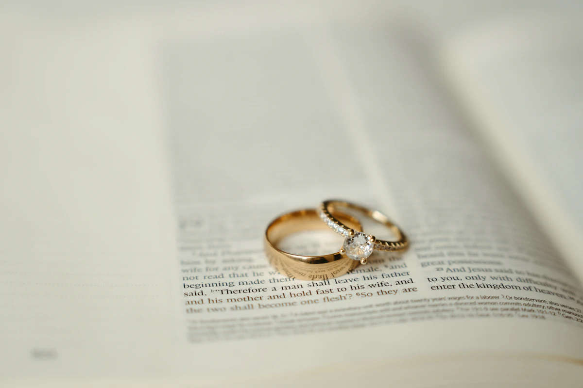 Dua cincin kawin emas di atas buku terbuka