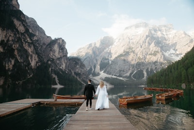 A bride and groom are standing on a dock