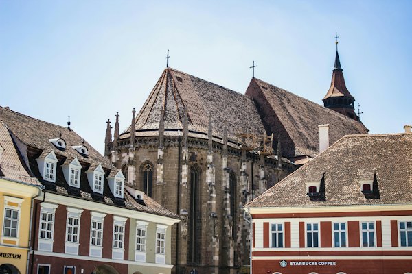 A group of buildings with a clock tower in the background — Brasov, Romania