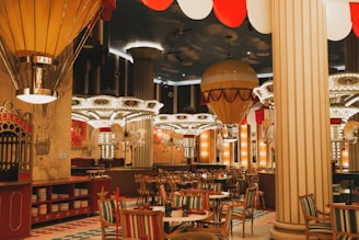 A restaurant with tables, chairs, and hot air balloons