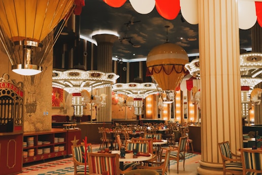 A restaurant with tables, chairs, and hot air balloons