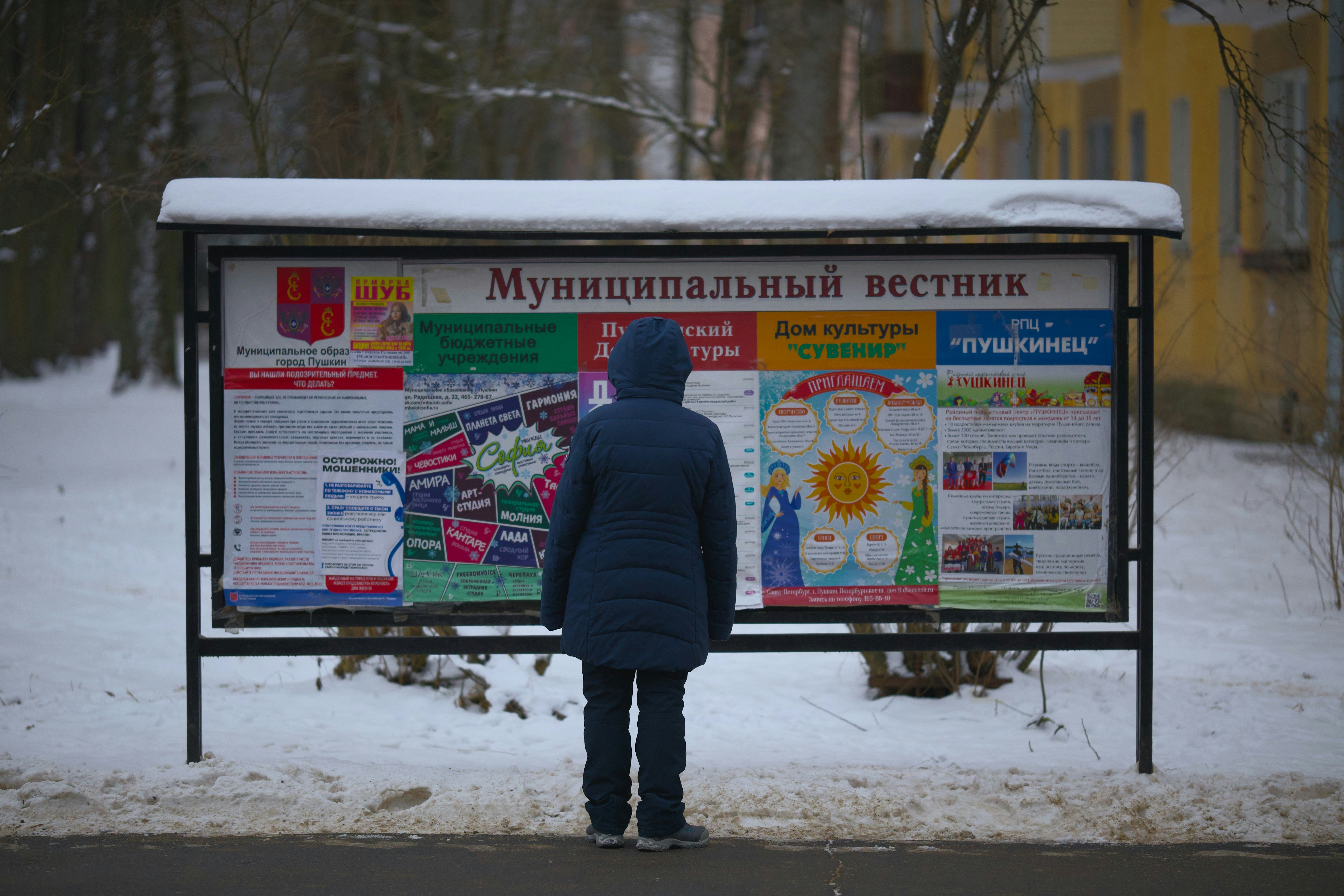 A person standing in front of a sign in the snow