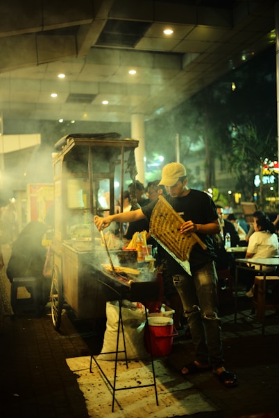 A group of people standing around a food cart