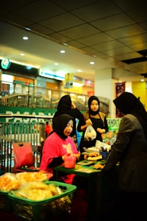 A group of people standing around a table filled with food