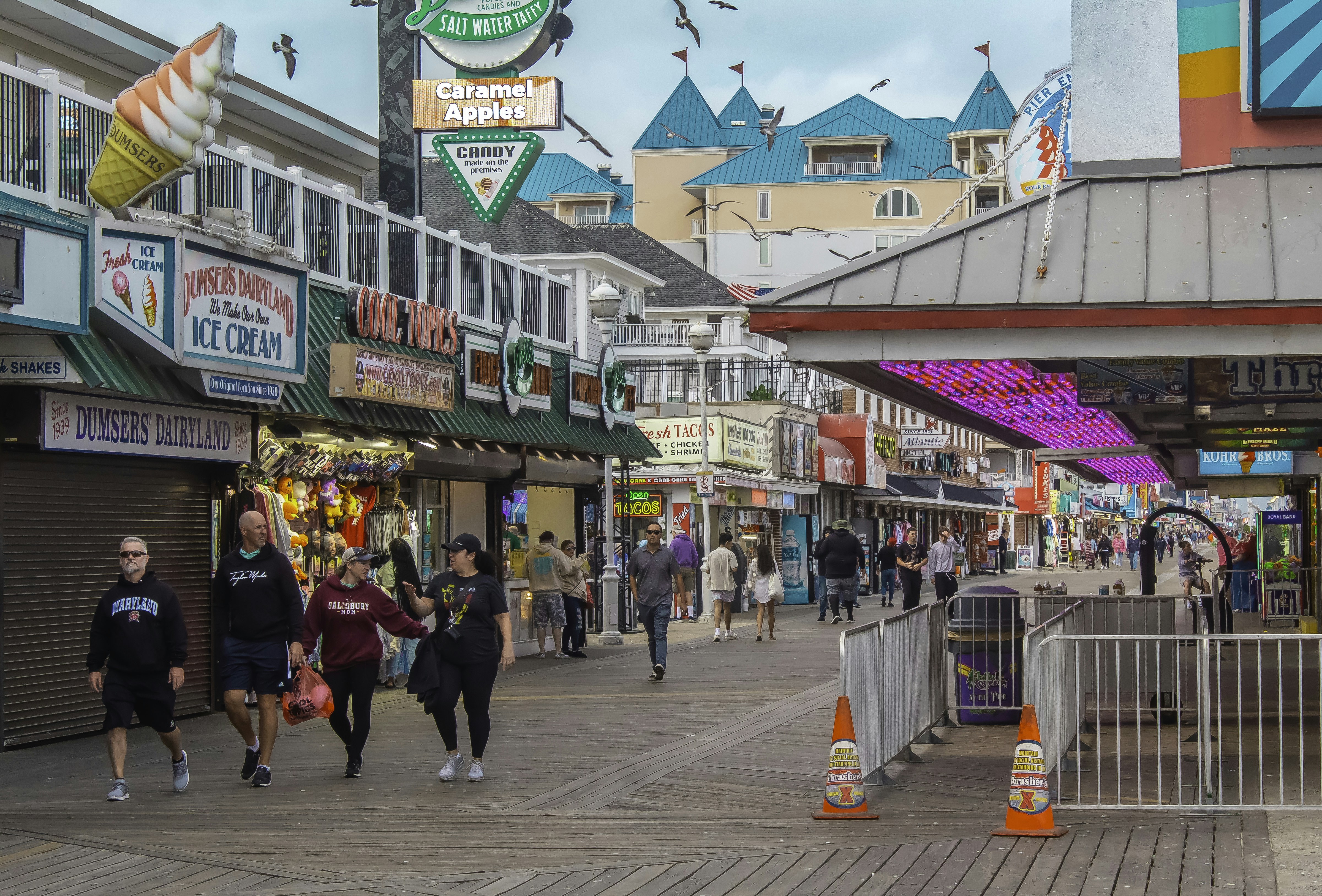 A group of people walking down a street next to shops
