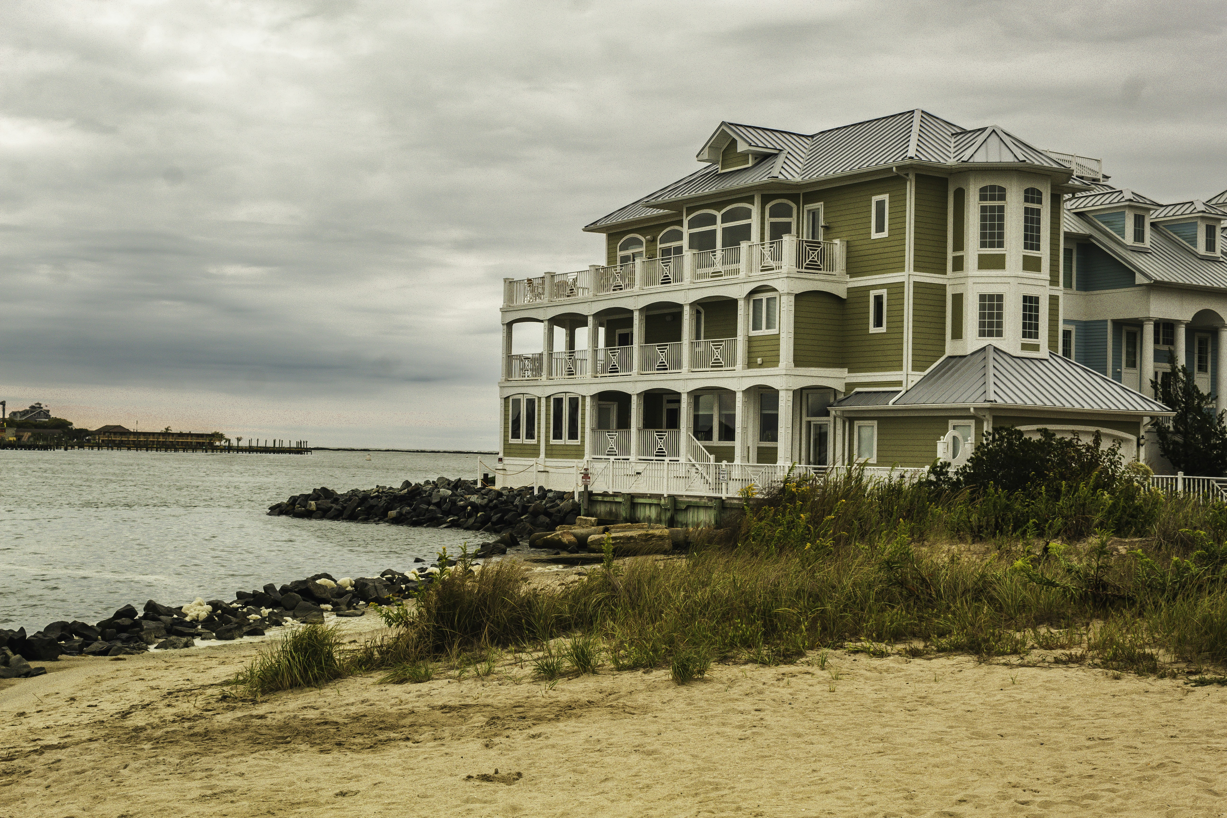 A large house sitting on top of a sandy beach