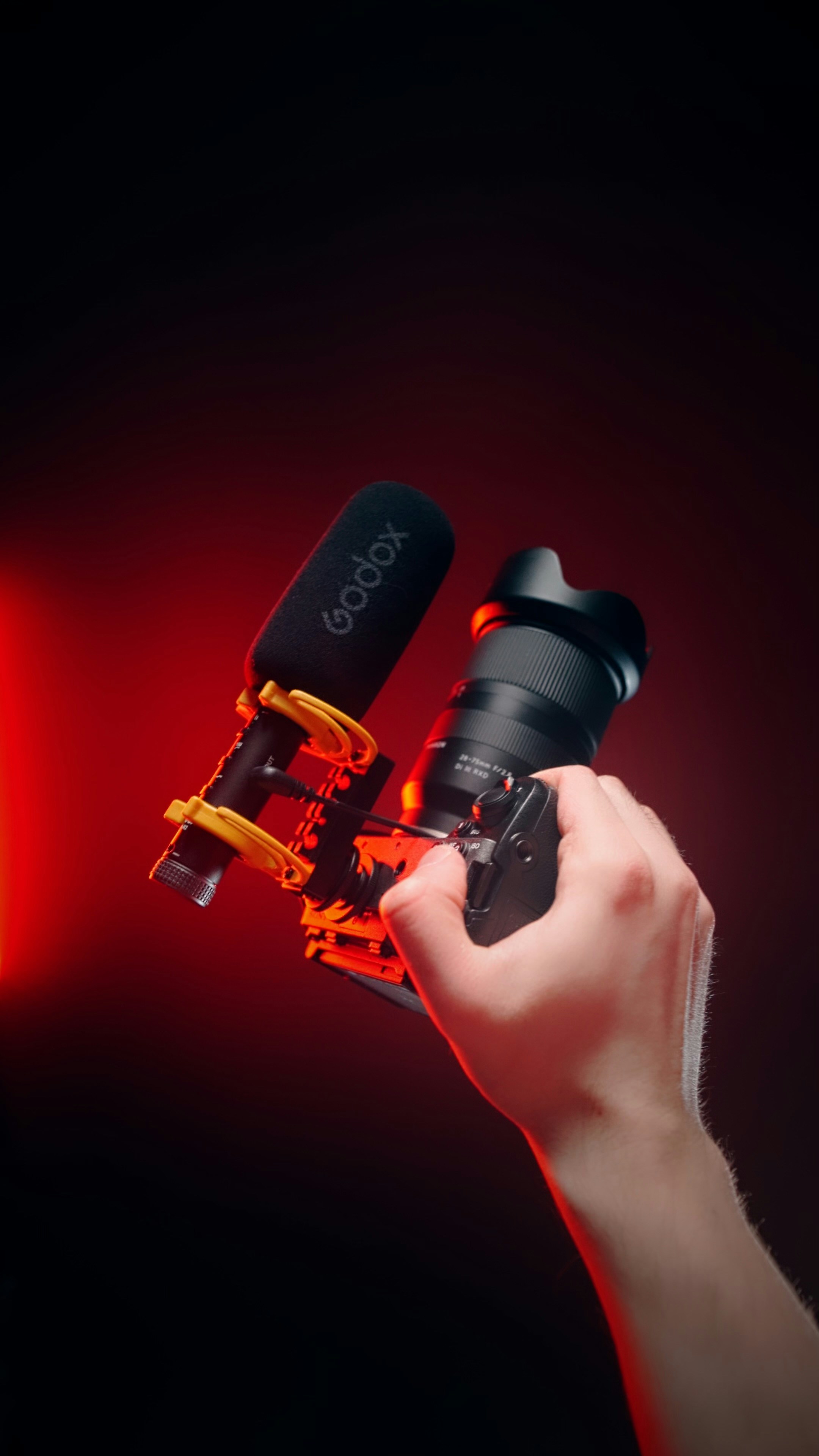 A hand holding a microphone in front of a red light