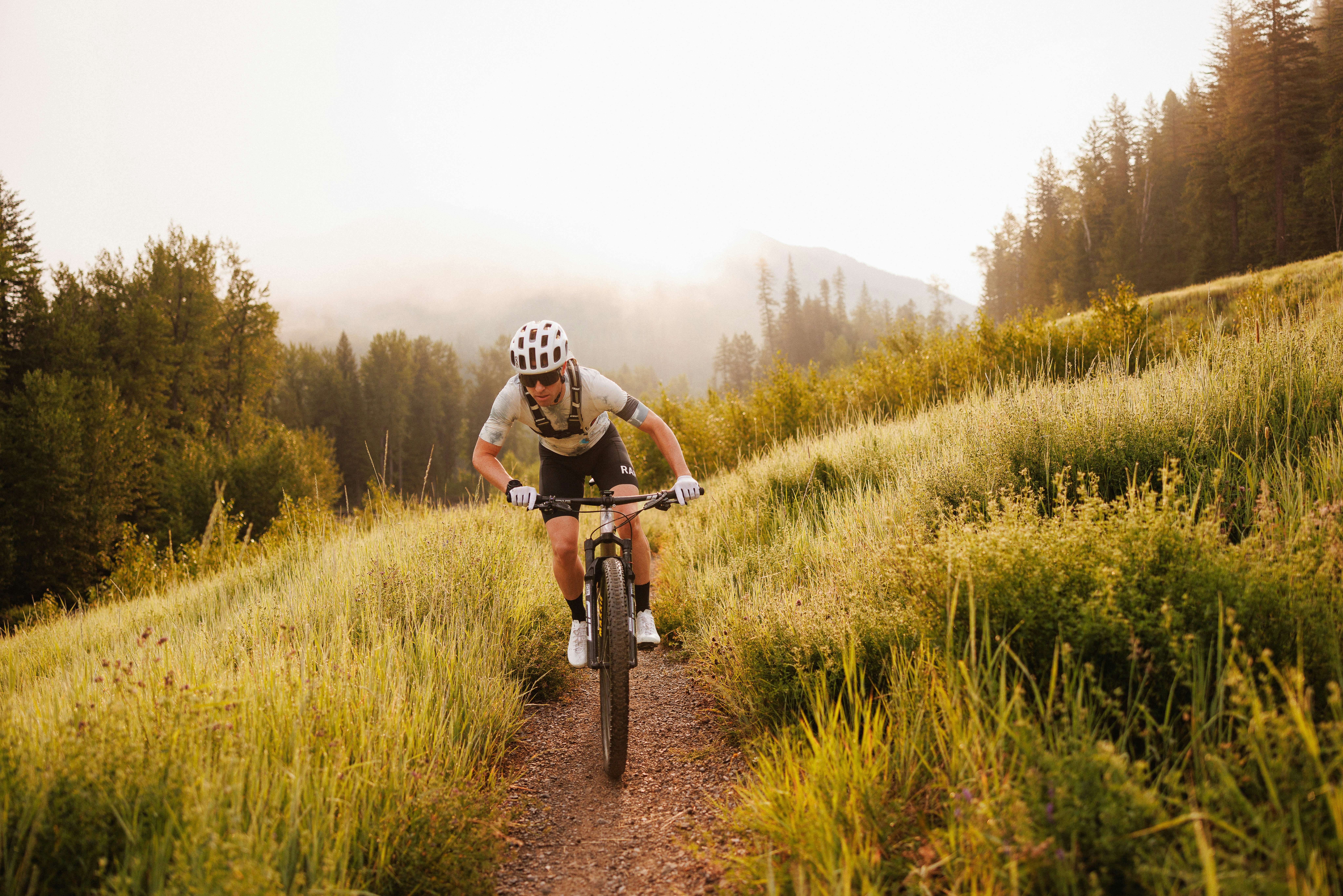 A man riding a bike down a dirt road