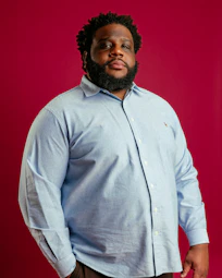 A man in a blue shirt and brown pants