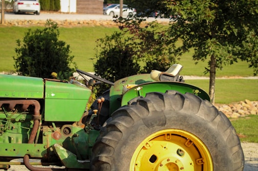 A green tractor parked in a parking lot