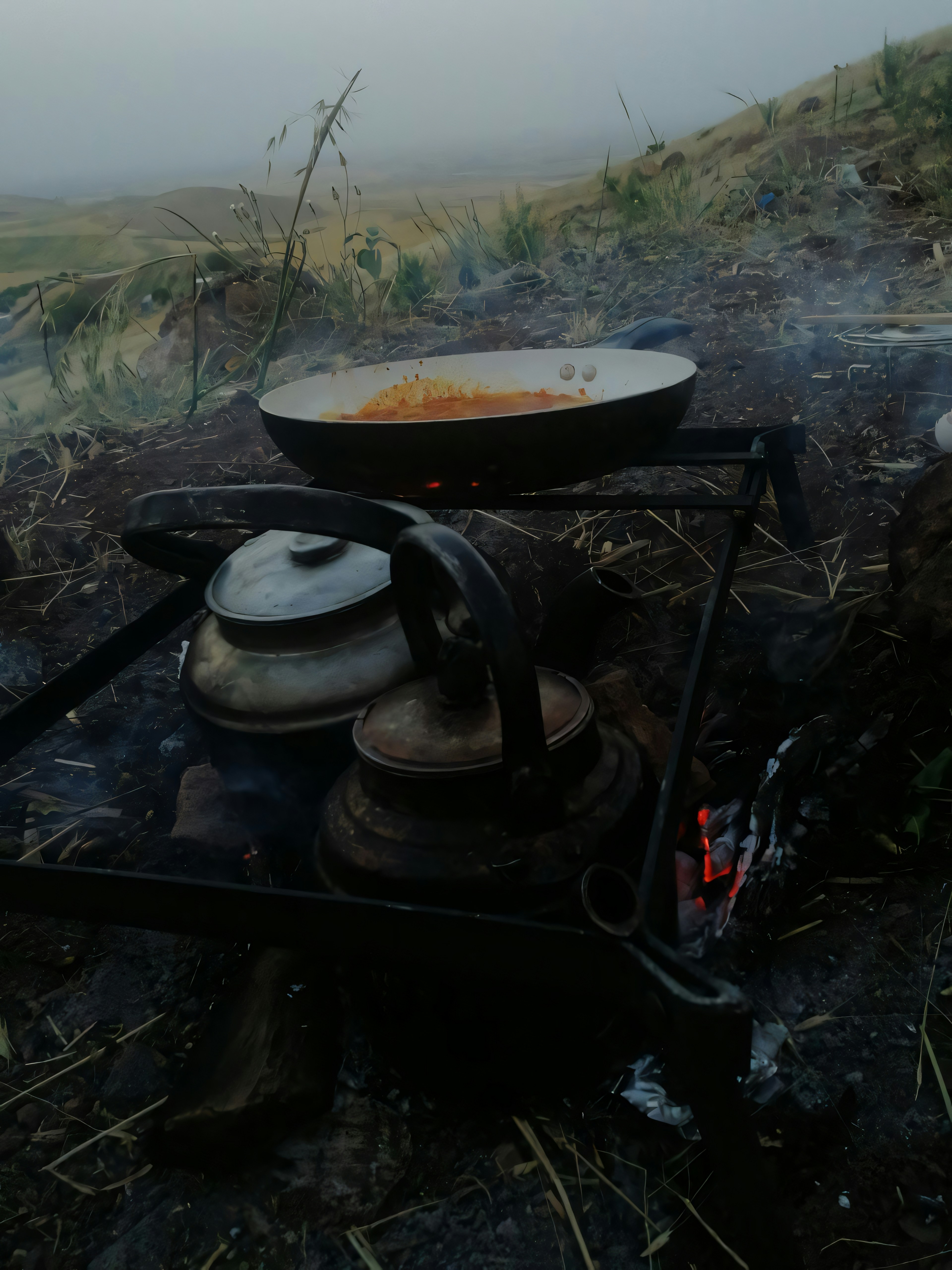 Camping cookware and stove equipment in use at an outdoor campsite