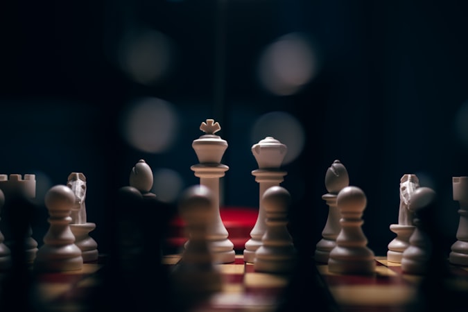 Chess pieces arranged on a board in cinematic lighting during a tense mid-game position