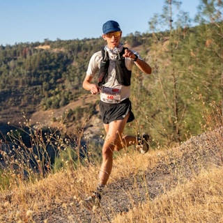 A man running on a trail in the mountains