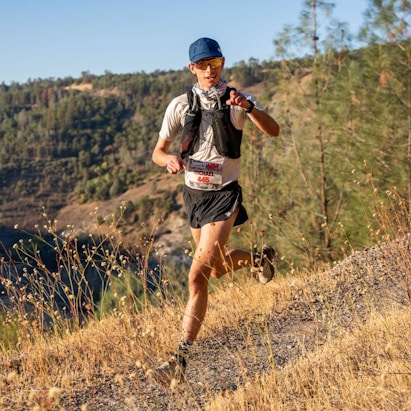 A man running on a trail in the mountains