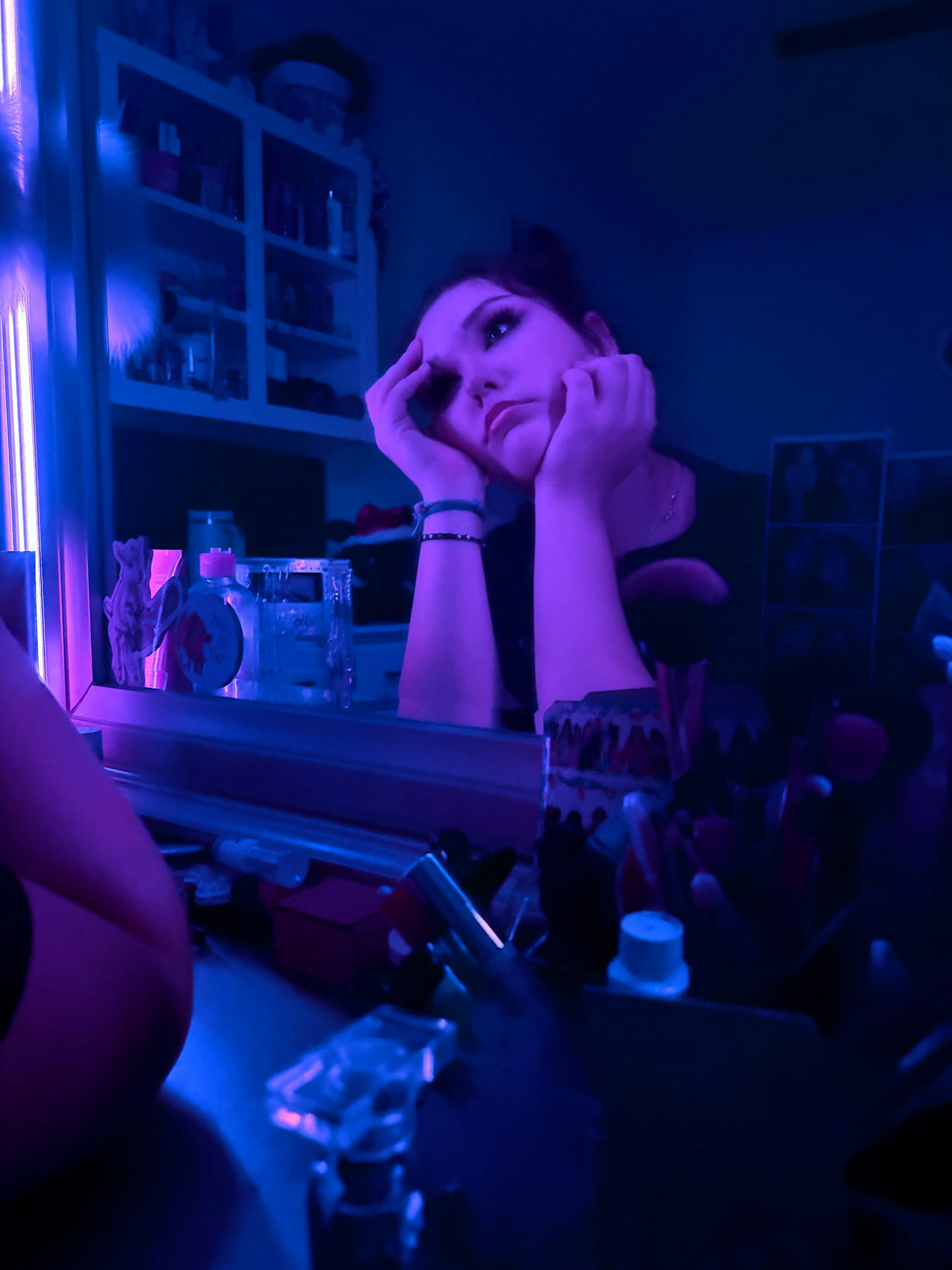 A woman sitting in front of a mirror in a room
