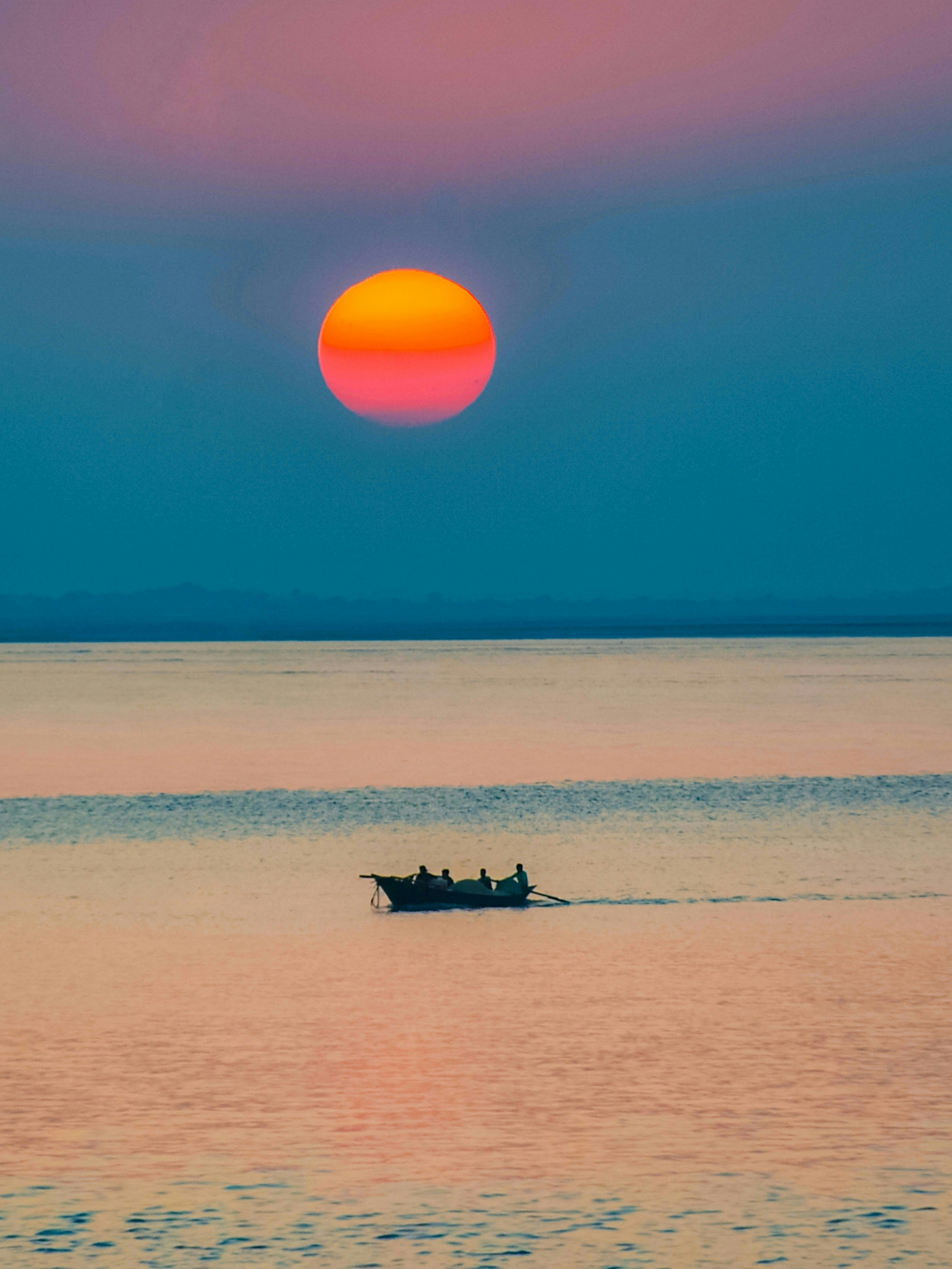 A couple of boats floating on top of a large body of water photo – Free ...