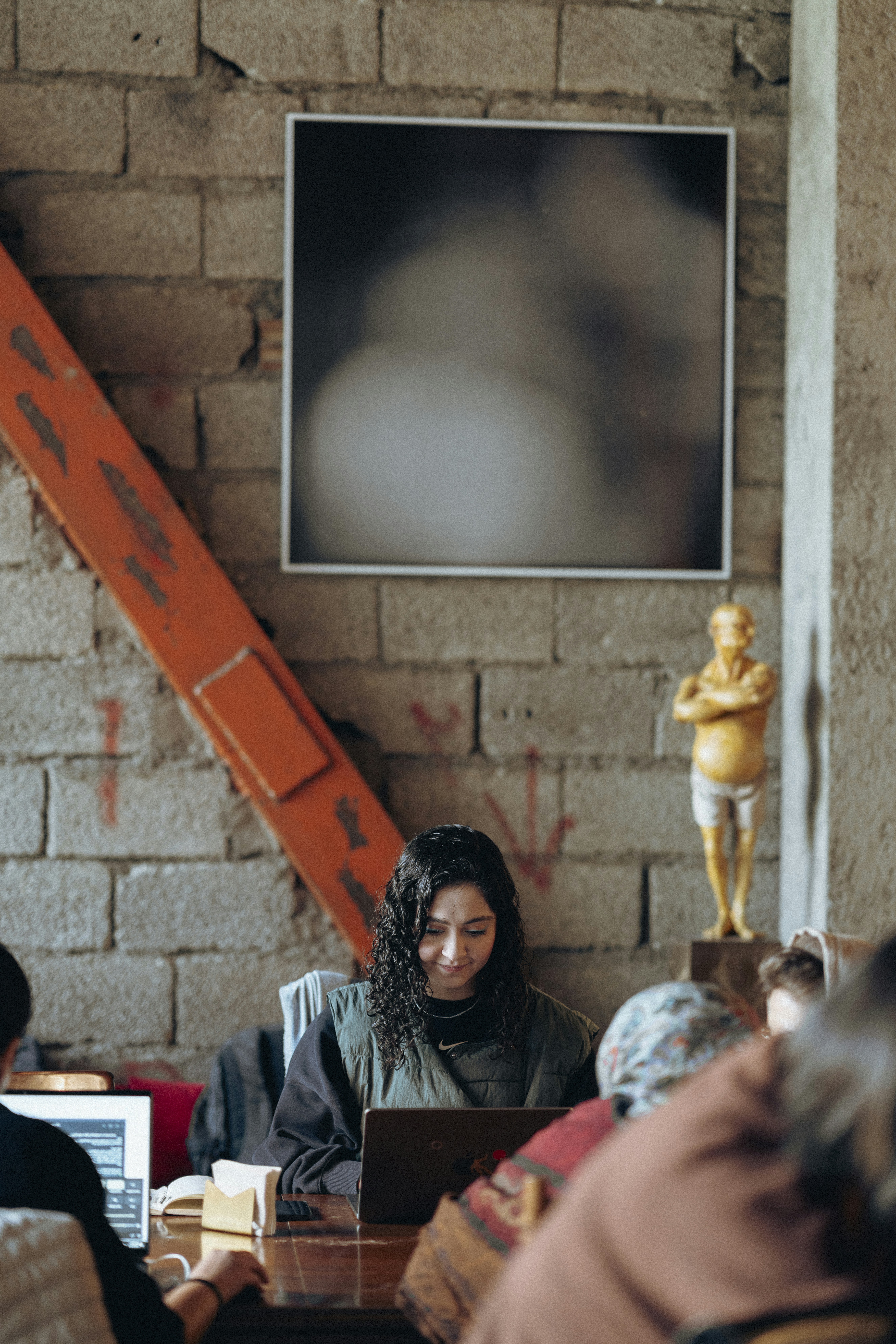 A group of people sitting around a table with laptops