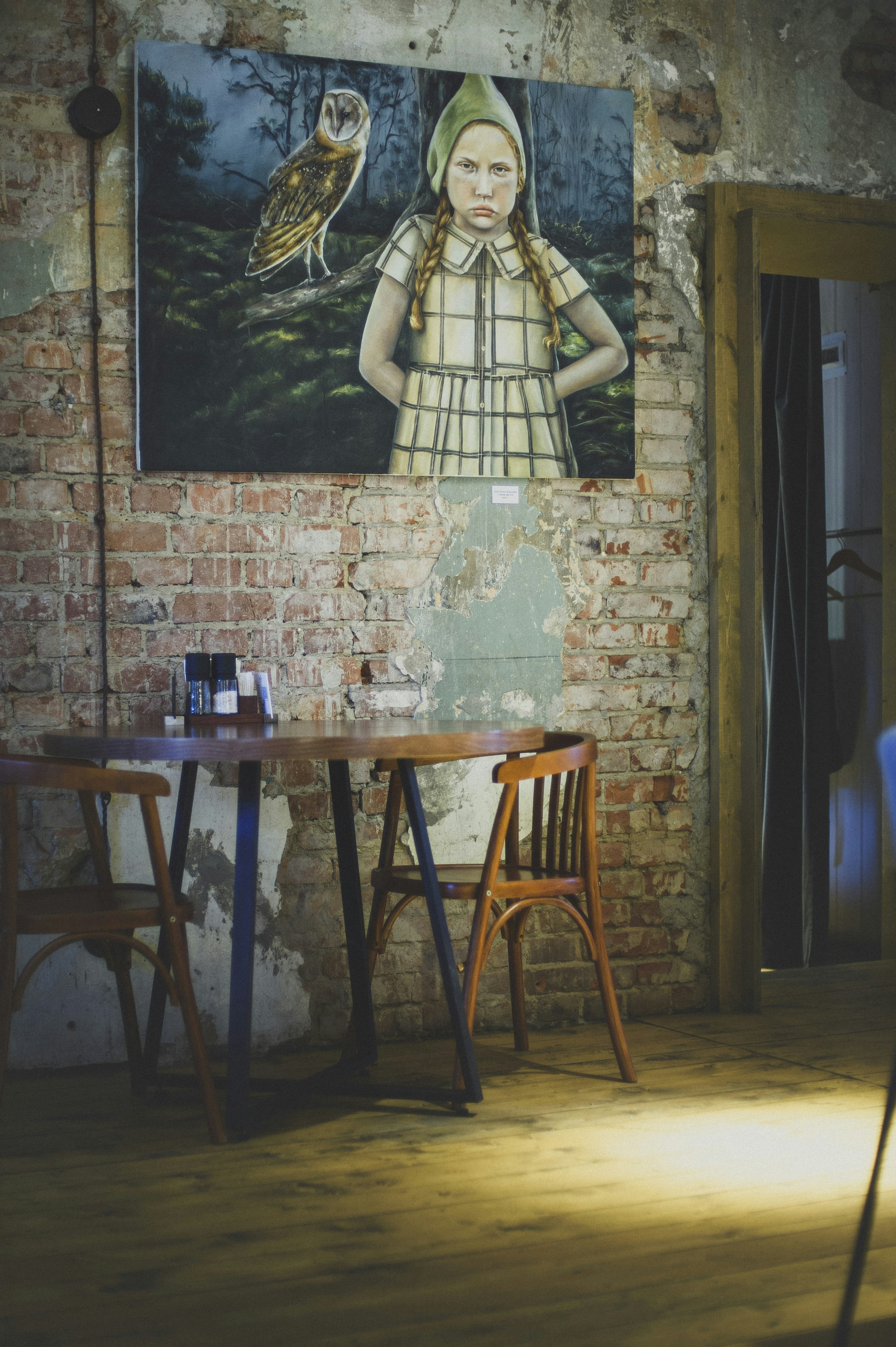 A room with a brick wall and a painting on the wall