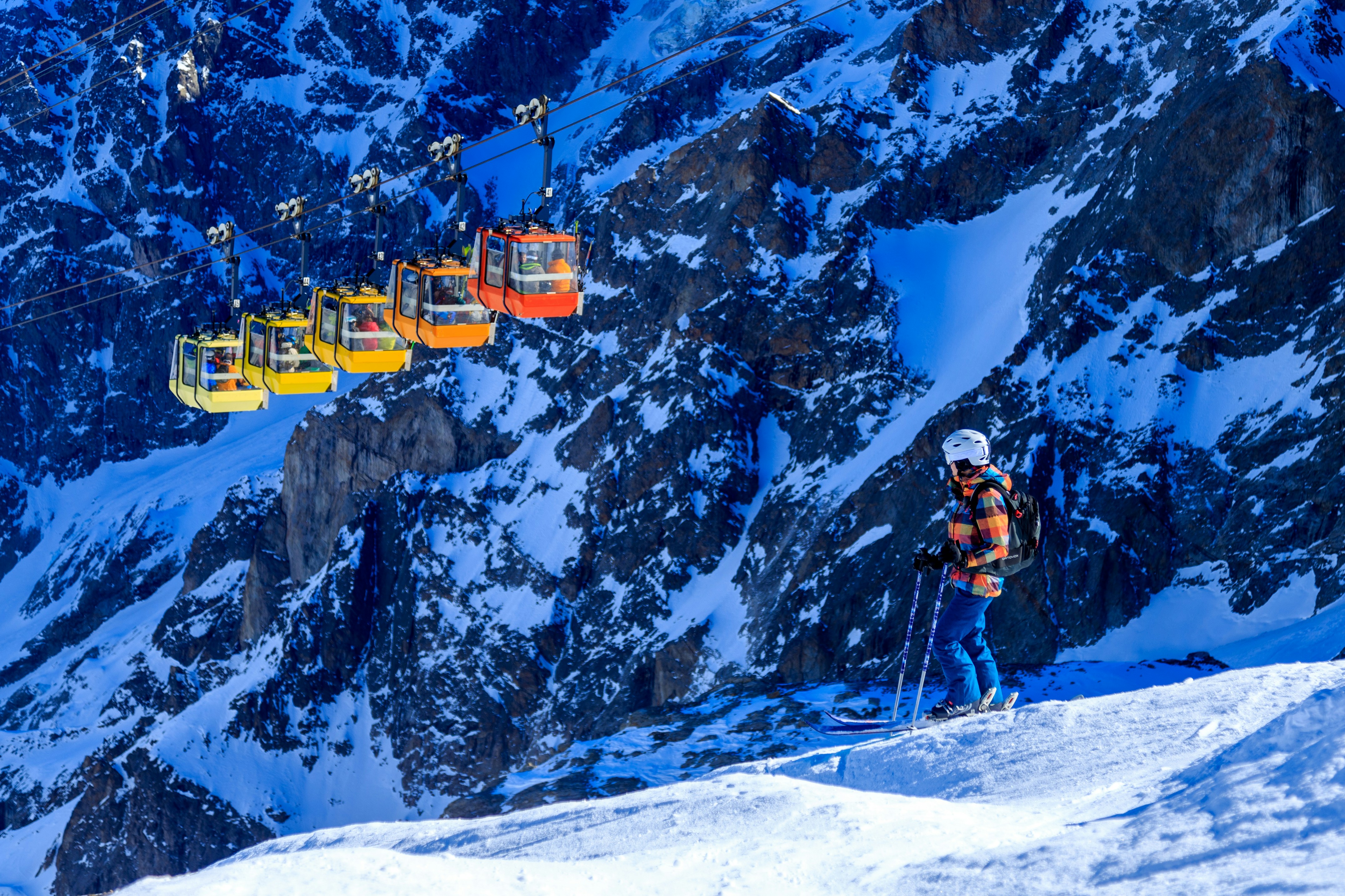 Un uomo che cavalca gli sci lungo il lato di un pendio coperto di neve