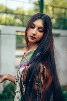 A woman with long hair standing in the grass