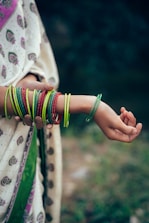 A woman holding a child's arm with bracelets on it