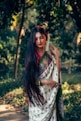 A woman in a sari is posing for a picture