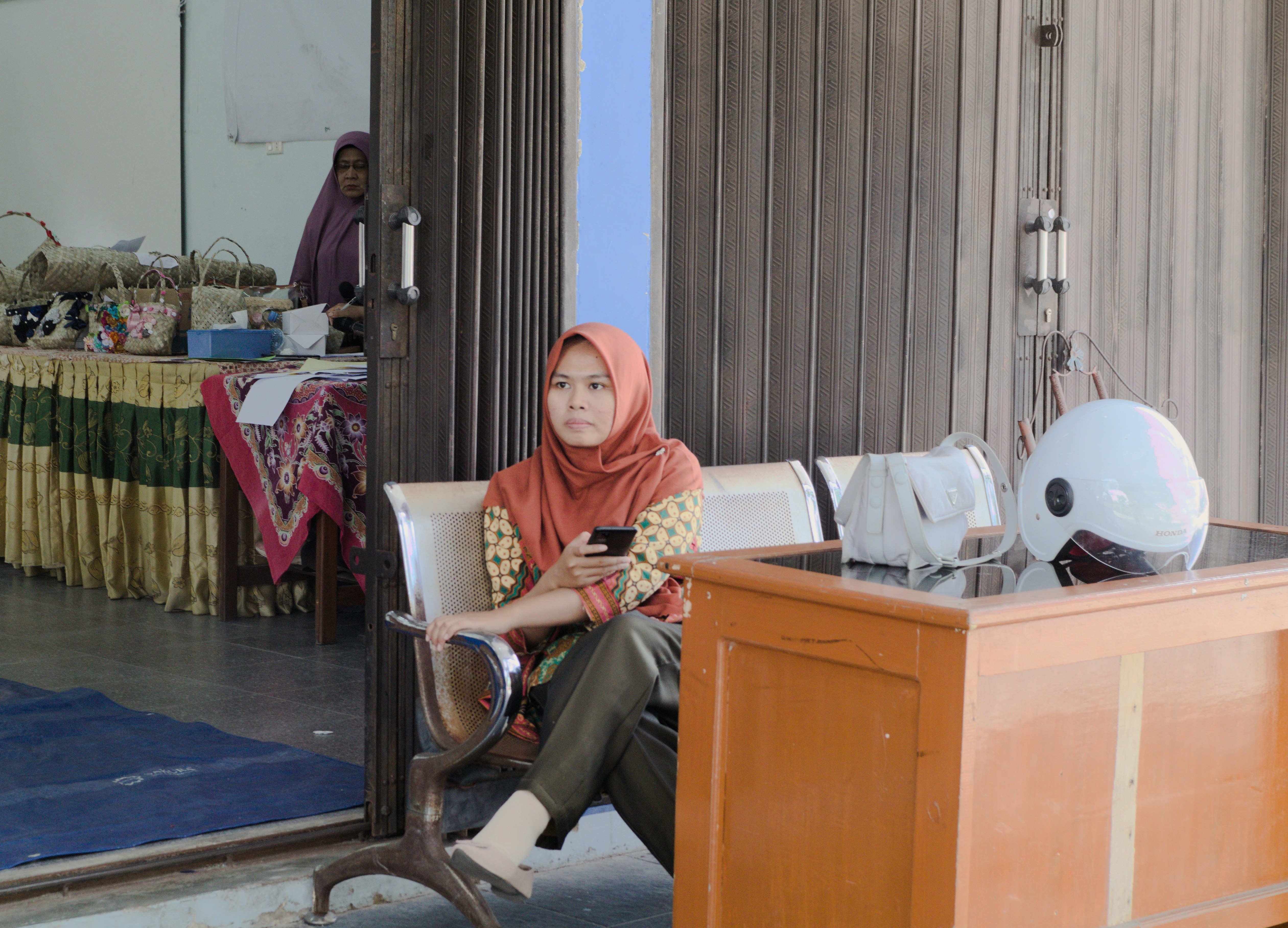 A woman sitting on a chair looking at her cell phone