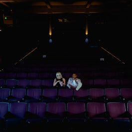 A couple of people sitting in a theater