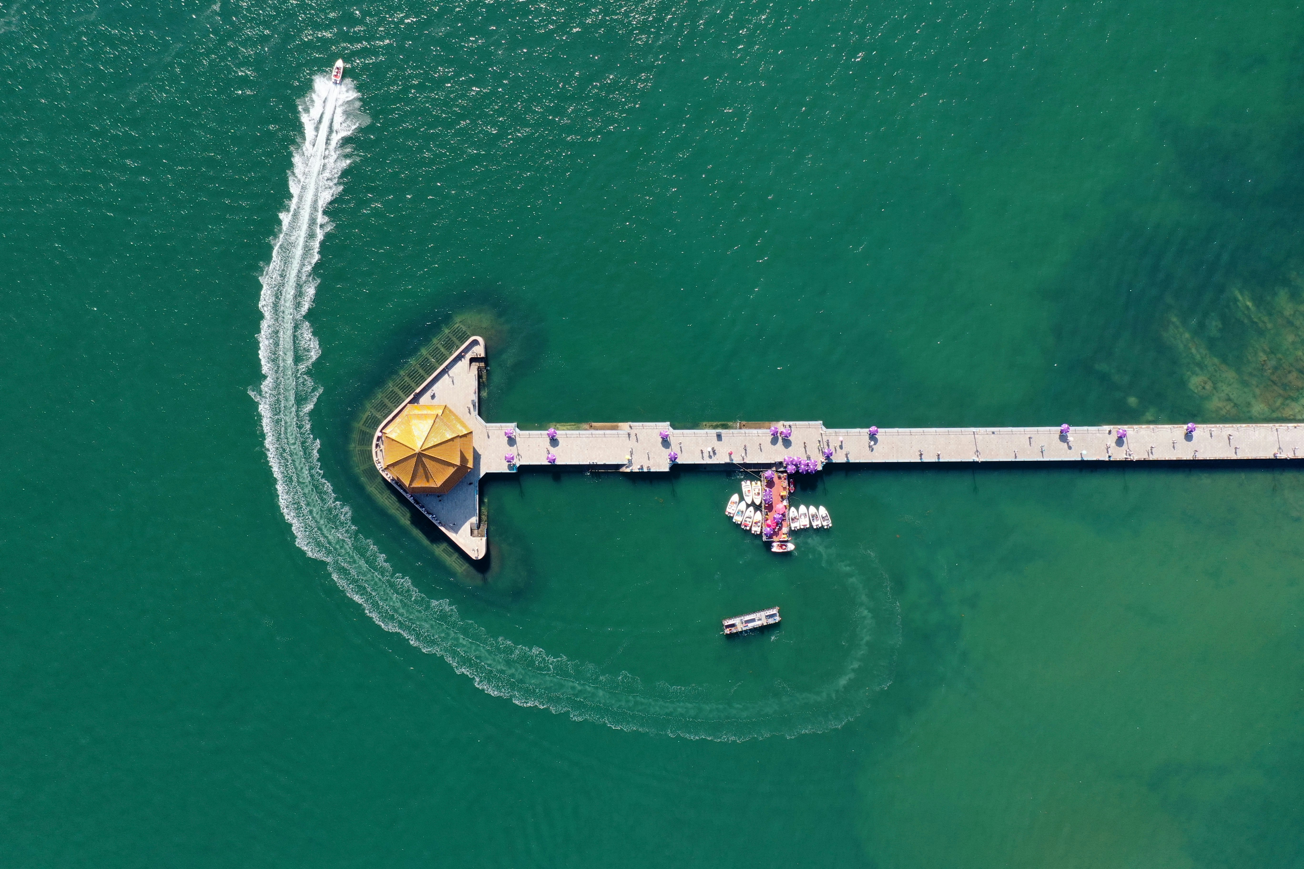 An aerial view of a pier with a boat in the water