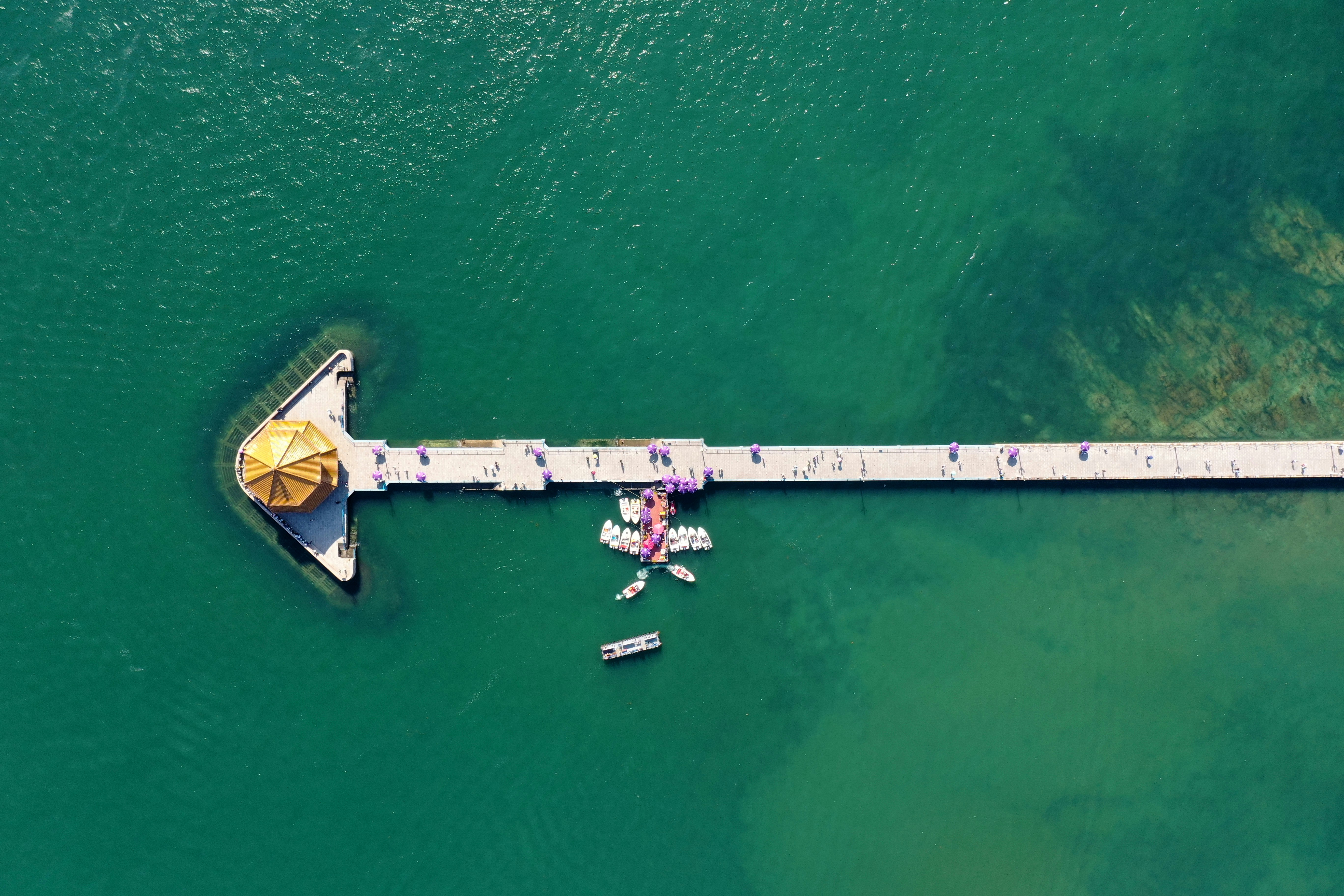 An aerial view of a pier with a boat in the water