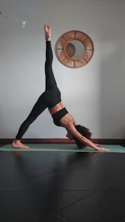 A woman is doing a yoga pose on a mat