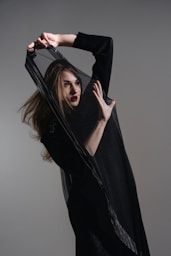 A woman in a black dress holding a black bag