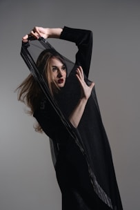 A woman in a black dress holding a black bag