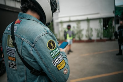 A man in a jean jacket with amazing patches on it