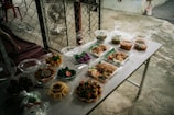 A table topped with lots of food next to a fence