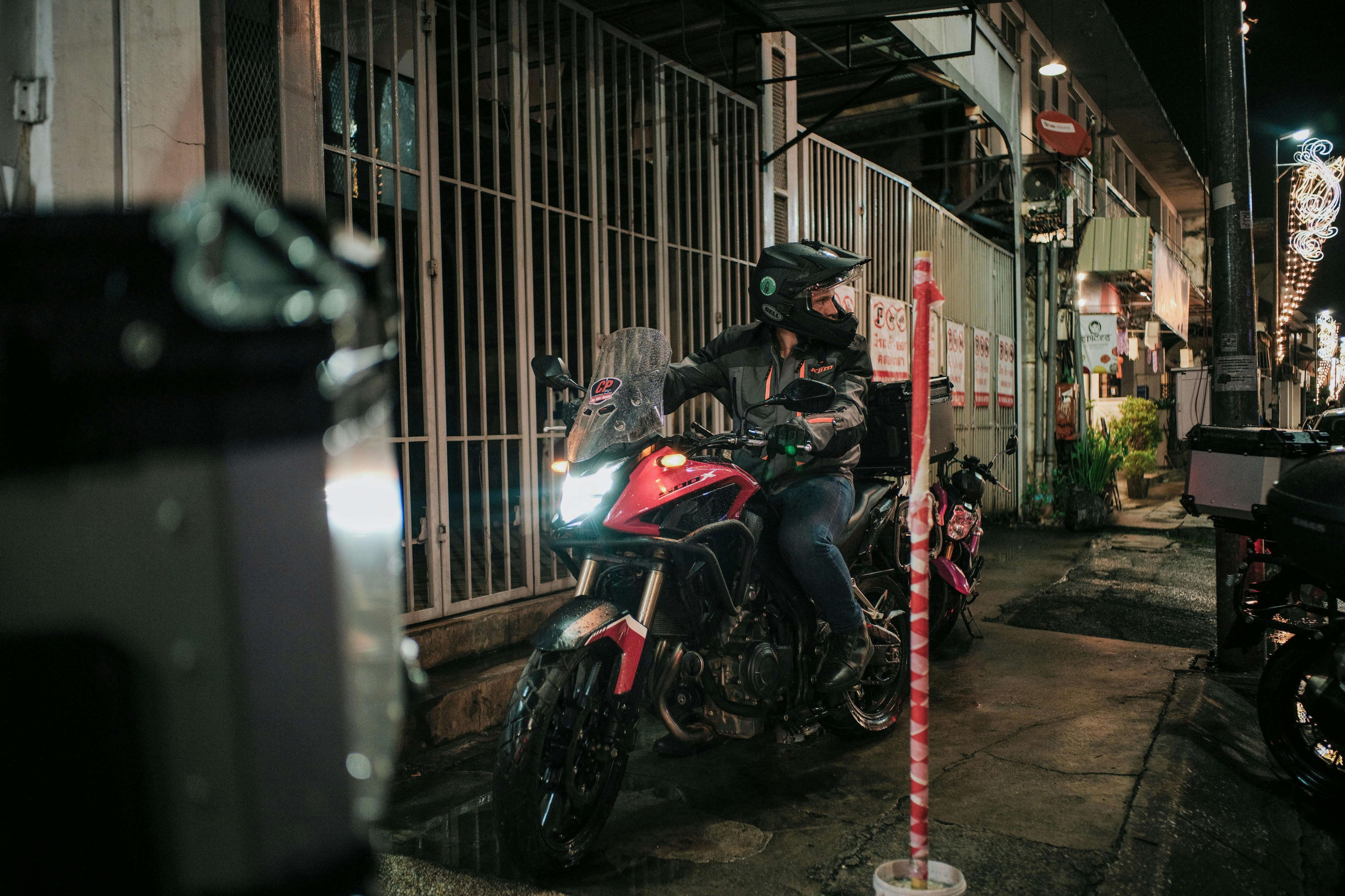 A man riding on the back of a red motorcycle