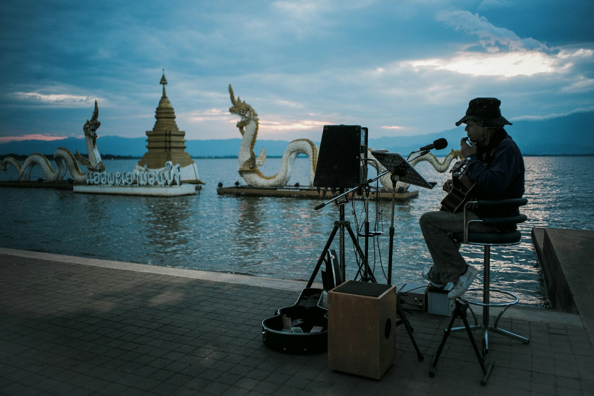 A man sitting on a chair next to a body of water