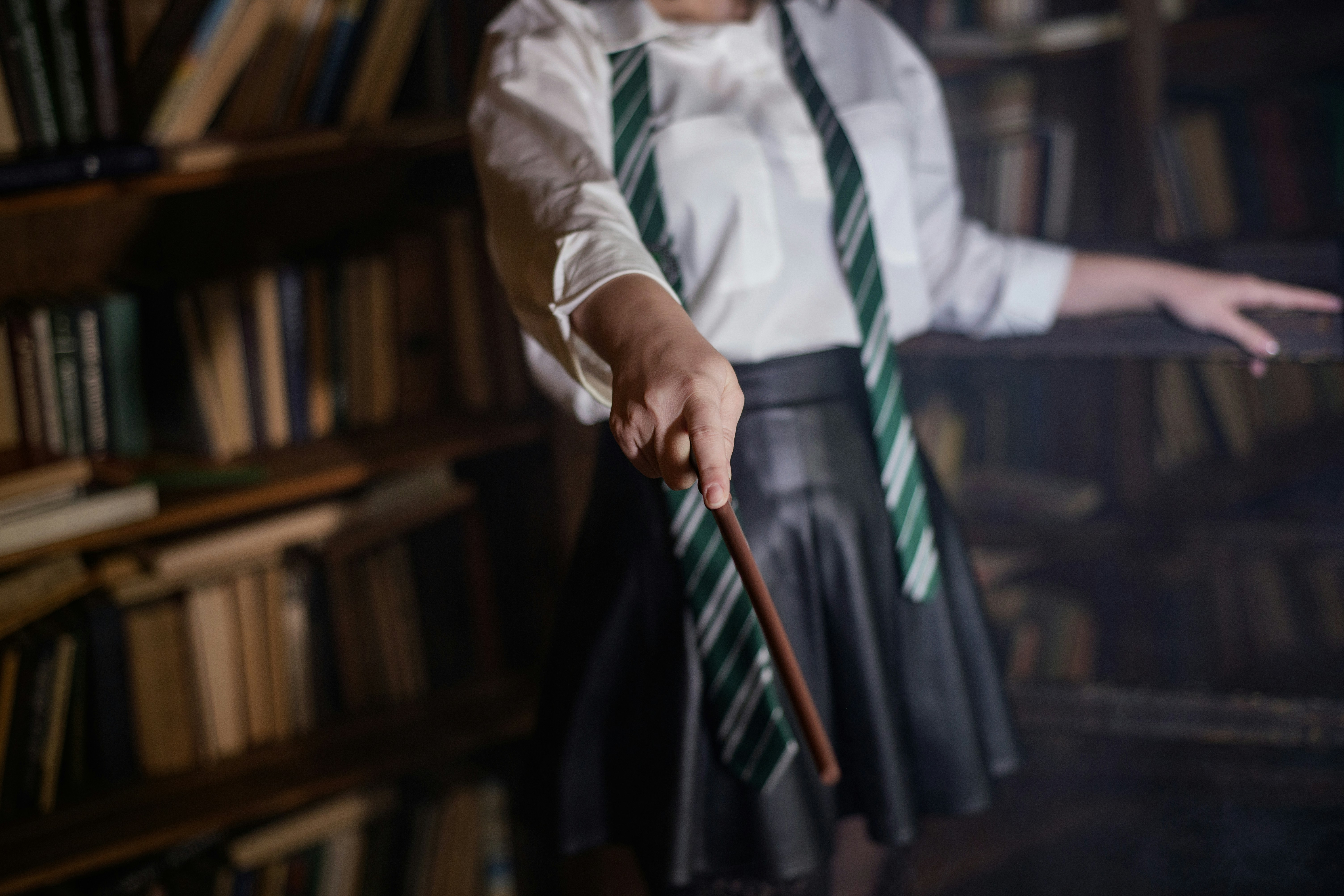 A woman in a white shirt and green tie holding a cane