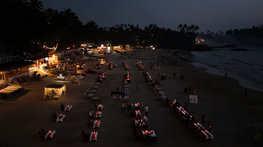 Candle-lit tables laid out on the sand at a beach shack after dark