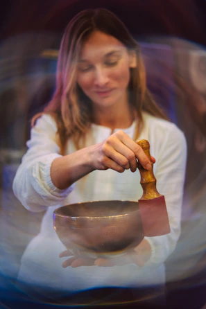 A woman mixing a bowl with a wooden spoon