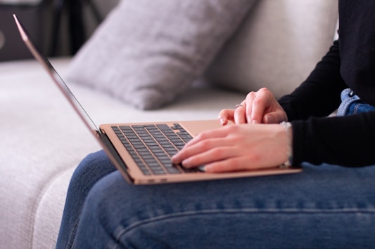 A woman sitting on a couch using a laptop computer