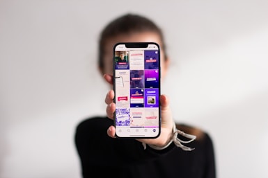 A person holding a cell phone up to their face