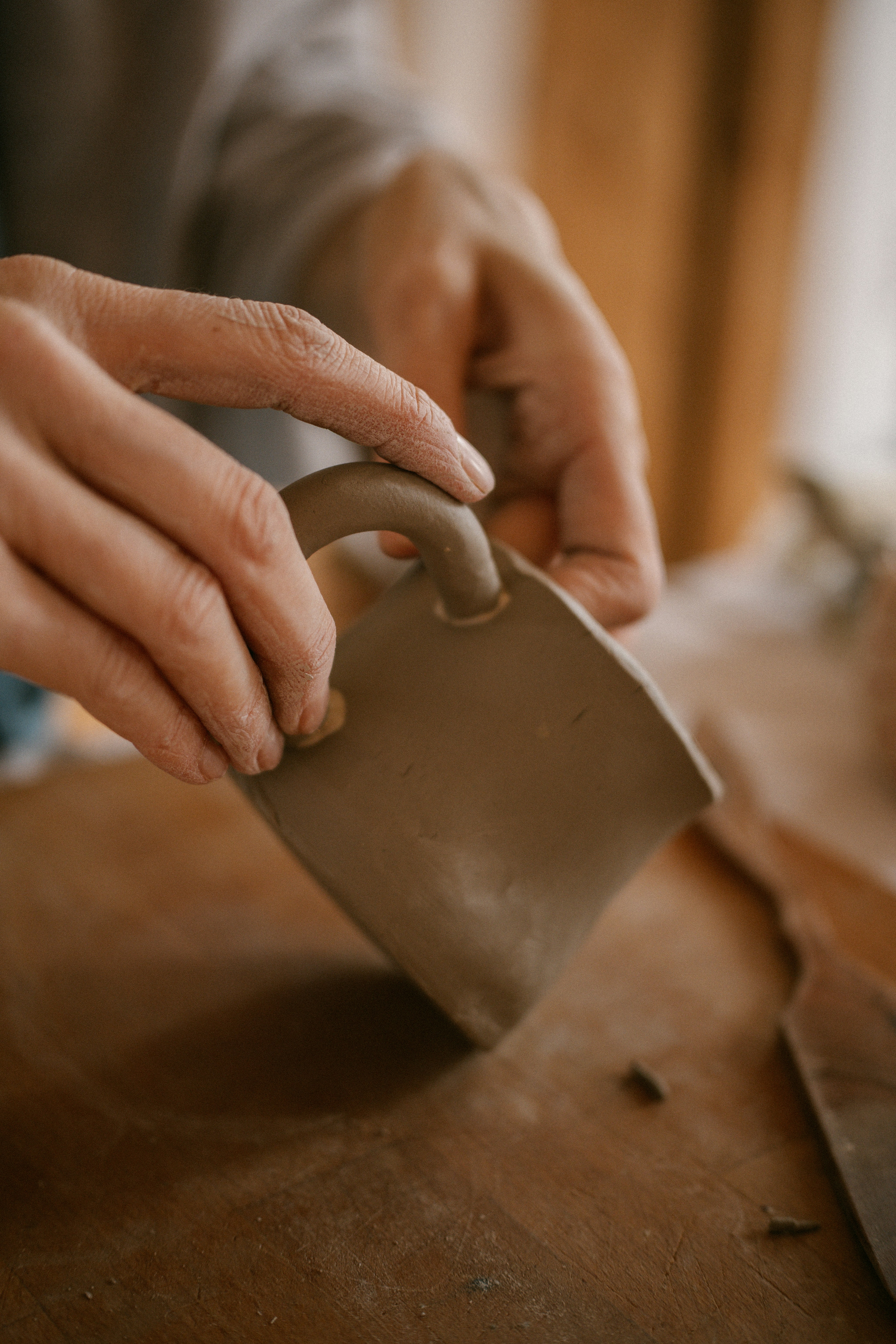 A person holding a knife on top of a wooden table
