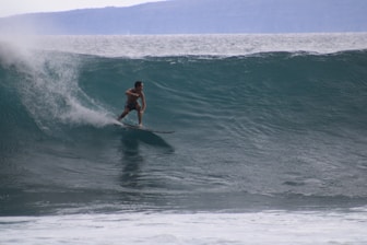 A man riding a wave on top of a surfboard