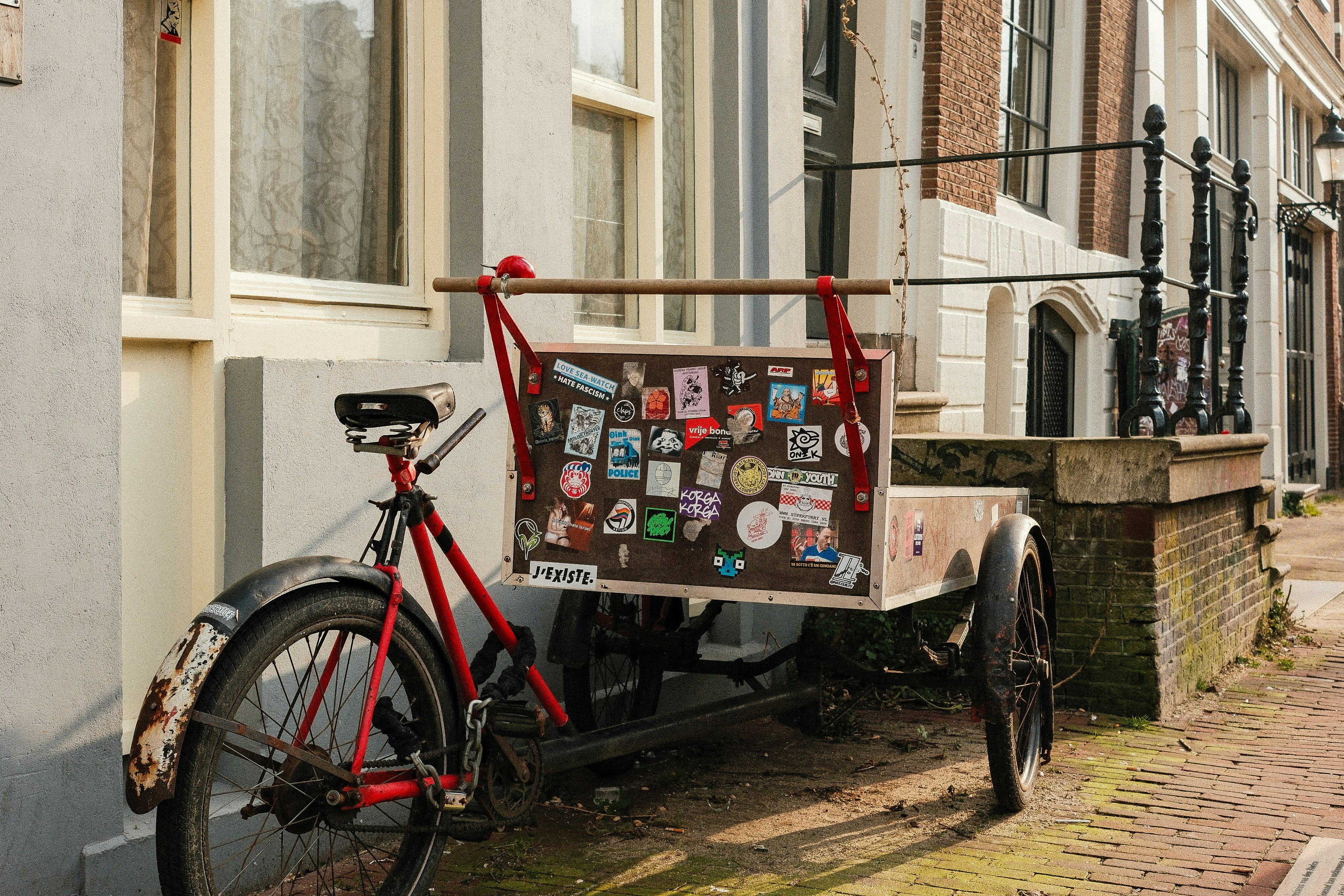 A red bike parked next to a building